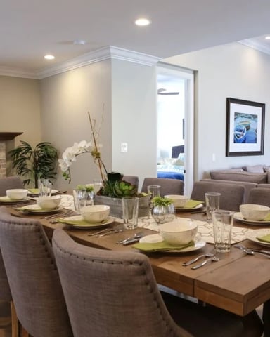 Open-plan dining and living room with set table, fireplace, and modern furnishings