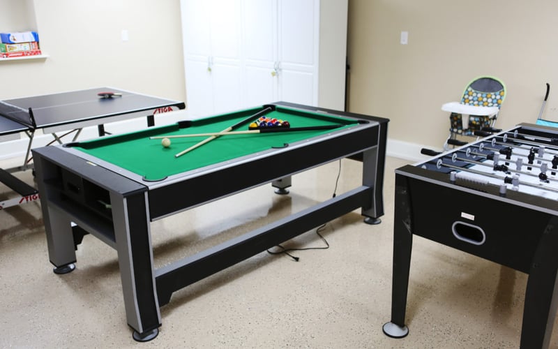 Game room with pool table, foosball table, ping pong table, and white closet doors