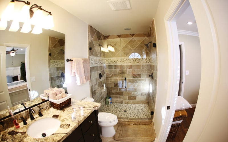 Master bathroom with granite countertop, dark vanity, large walk-in shower with tile surround and glass enclosure